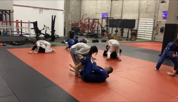A full and intense Brazilian Jiu-Jitsu class in session, with students of all levels learning techniques, sparring, and pushing their physical and mental limits in a supportive and challenging environment.