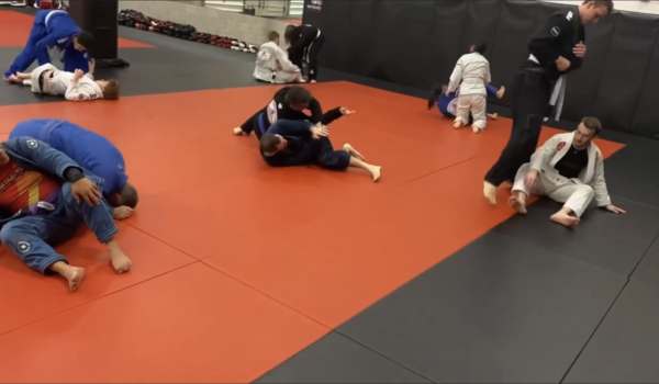 Students of all levels participating in a comprehensive Brazilian Jiu-Jitsu class, where they are honing their skills, engaging in sparring, and improving their physical and mental abilities in a motivating and stimulating setting