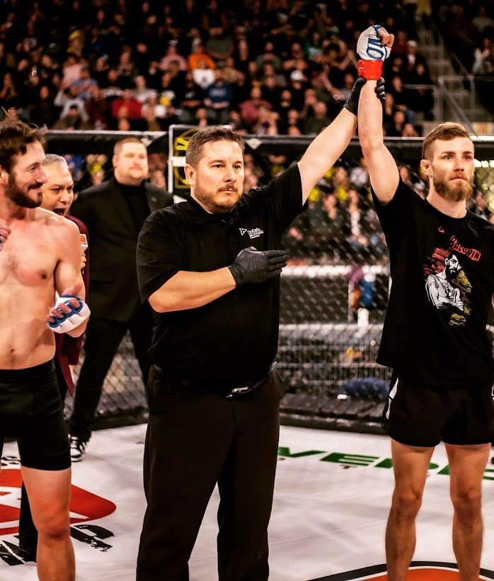 Zach Baldwin's pro MMA debut as he stands in the center of the octagon with his hand raised in victory